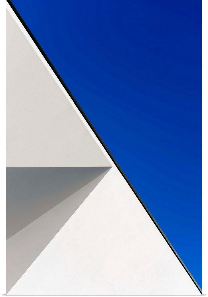 Side of a white building against a blue sky, creating an astract geometric image.