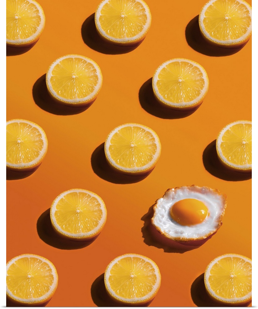 Lemon slices pattern with a fried egg, yellow background, abstract, surprise concept.
