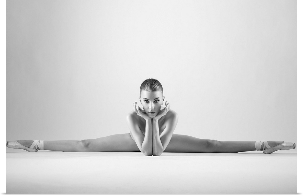 A ballerina in a split pose with toes pointed outwards.
