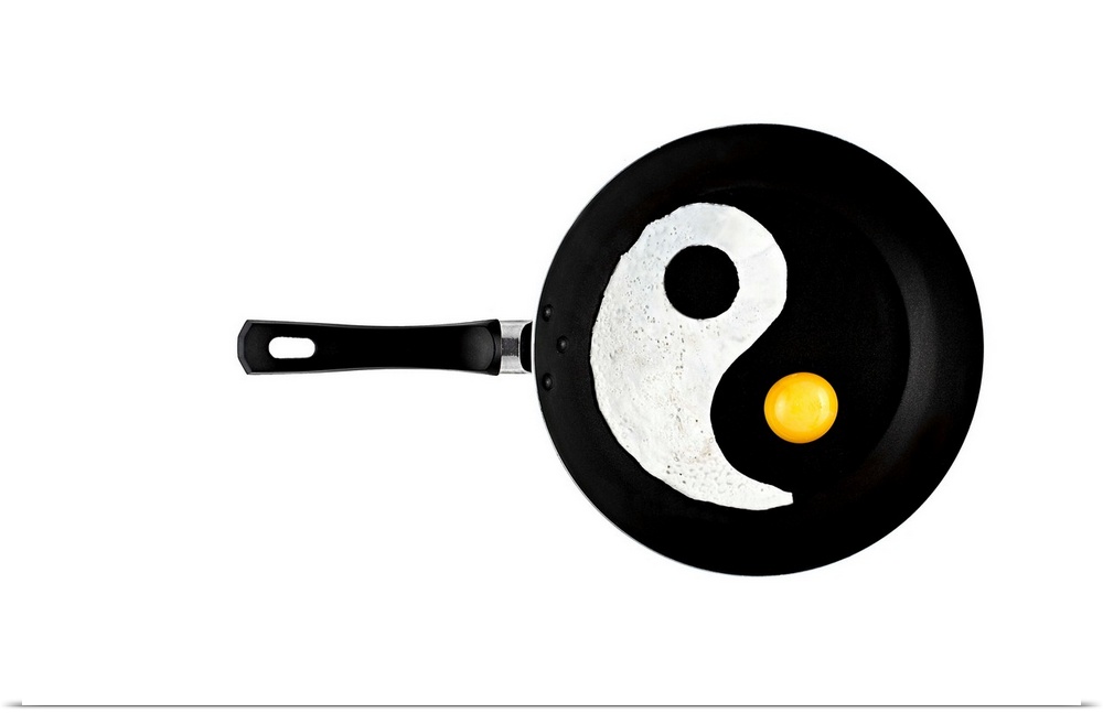 A frying pan with an eggwhite and yolk separated to resemble a yin yang symbol.