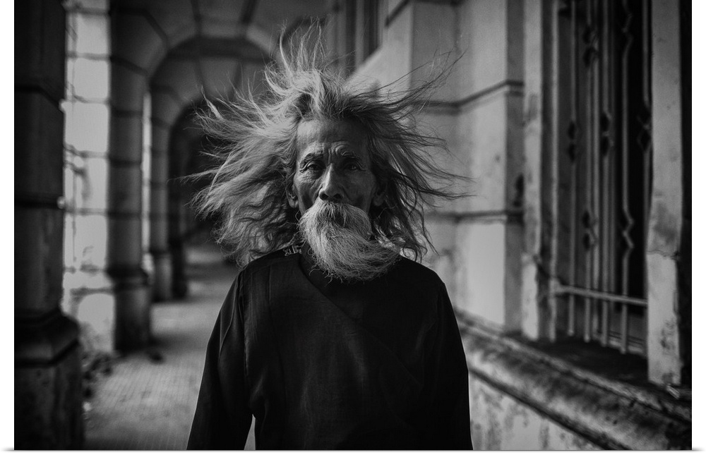 A portrait of an old man with wind blown hair.