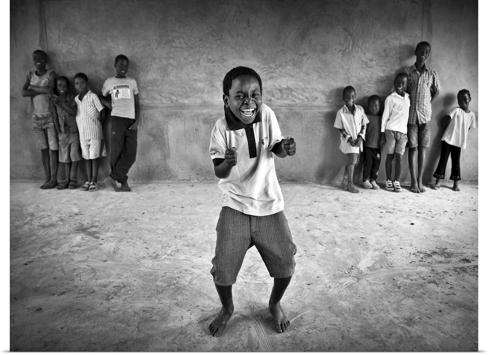 Portrait of a little boy dancing and have a laugh while other children watch him.