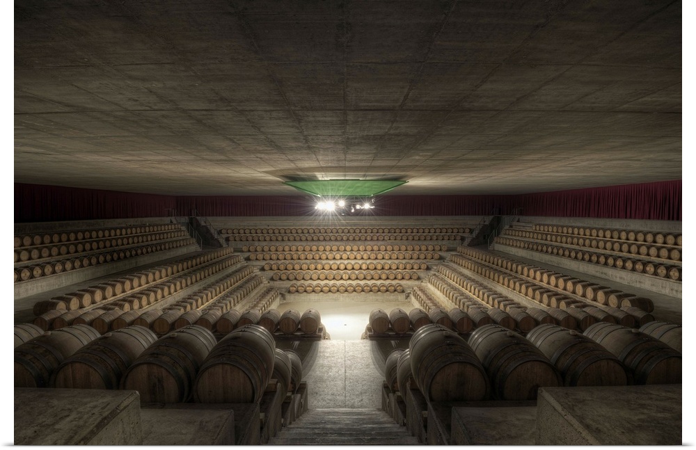 Inside a Tuscan wine cellar looking down into a pit-like arena surrounded by casks of wine, Italy.