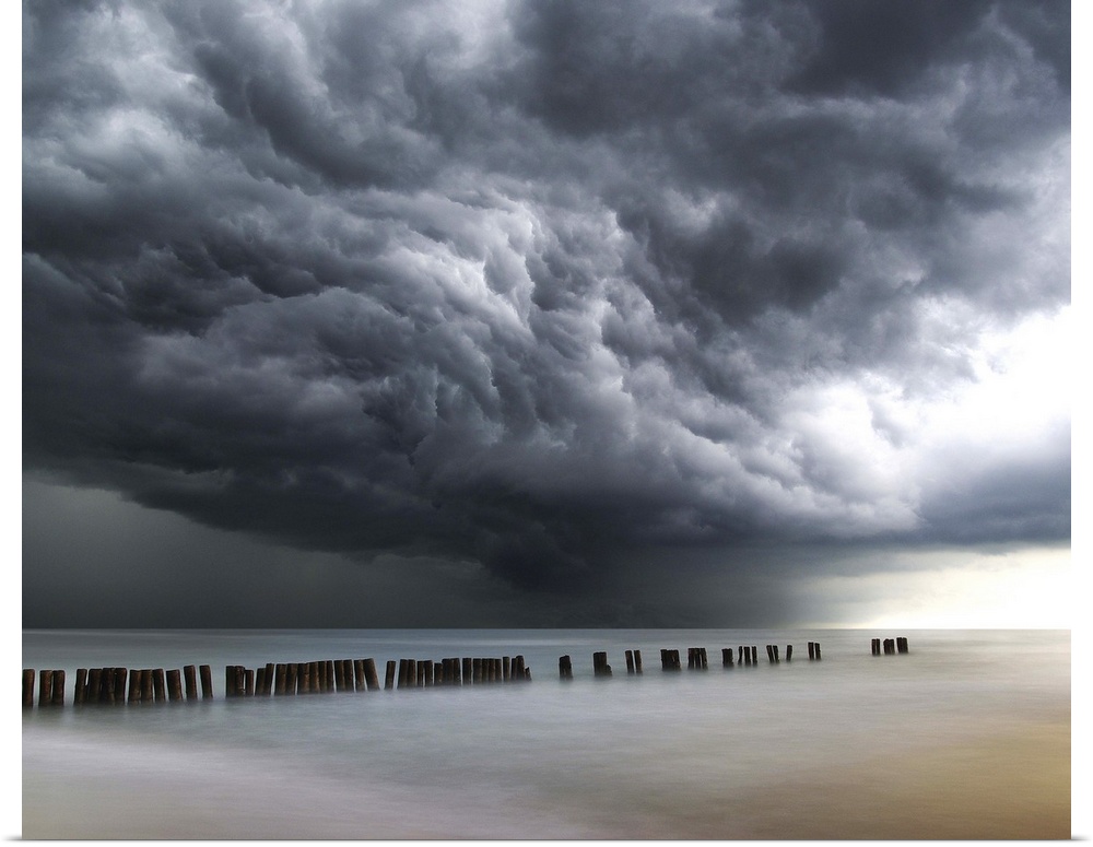 Photograph of dark, dramatic clouds rolling in over the ocean before a thunderstorm.