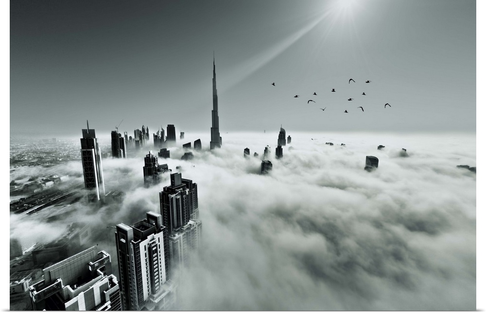 Aerial view above the clouds of the tops of skyscrapers and the sun in the sky, Dubai.