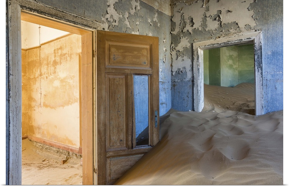 Photograph of an abandoned home interior now filled with the desert sand.