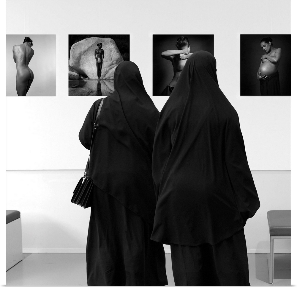 Two women wearing veils looking at fine art in a museum.