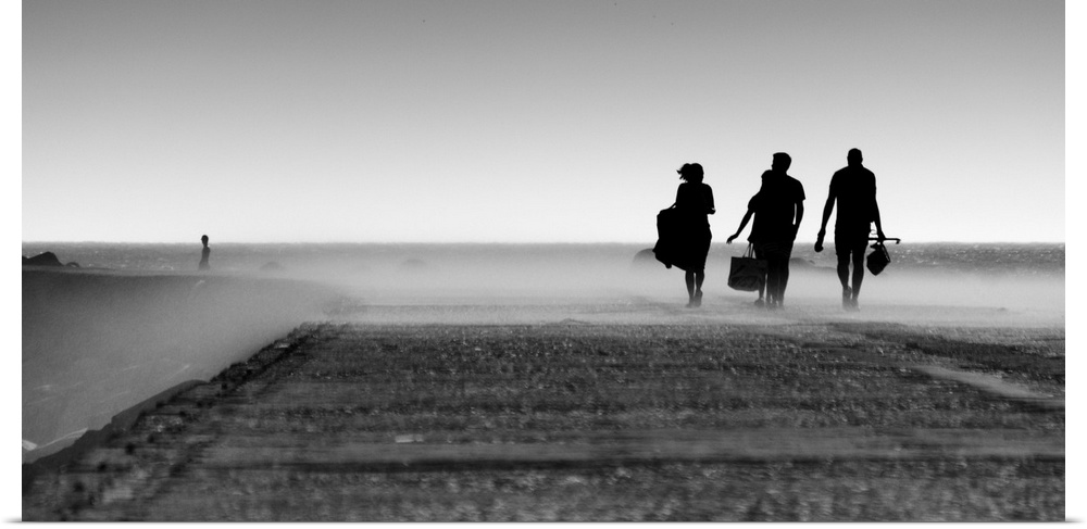 A black and white photograph of three silhouetted figures walking toward a mist.