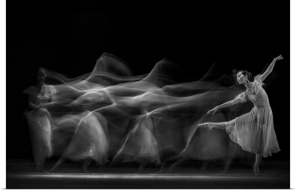 Blurred motion image of a ballerina dancing on a stage.