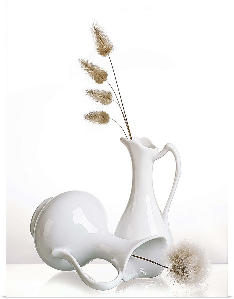 Two white pitchers with puffy flowers on a white background.