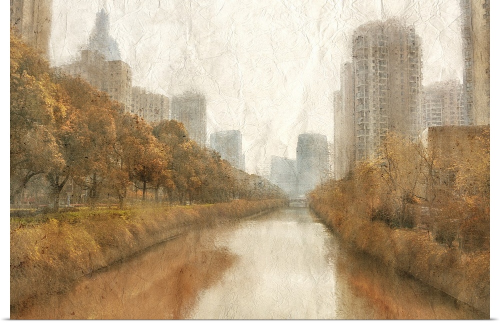 Fall scene of a river in a city with skyscrapers and orange trees.