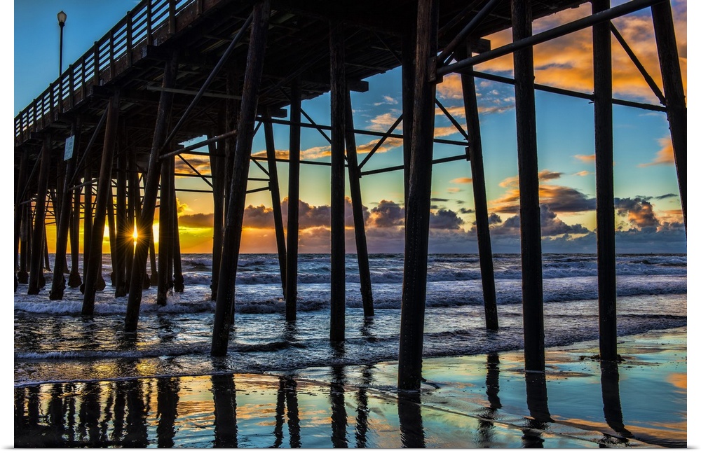 The sun peaks through the pilons of the Oceanside Pier. Oceanside is 35 miles North of San Diego, California, USA