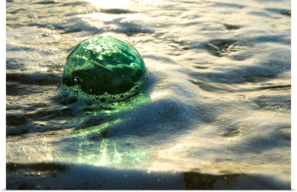 A Glass Fishing Ball Floats In Shallow Water