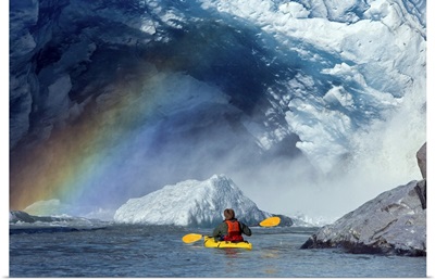 A kayaker explores a melt stream gushing from beneath Mendenhall Glacier