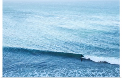 A lone surfer rides a Pacific wave.
