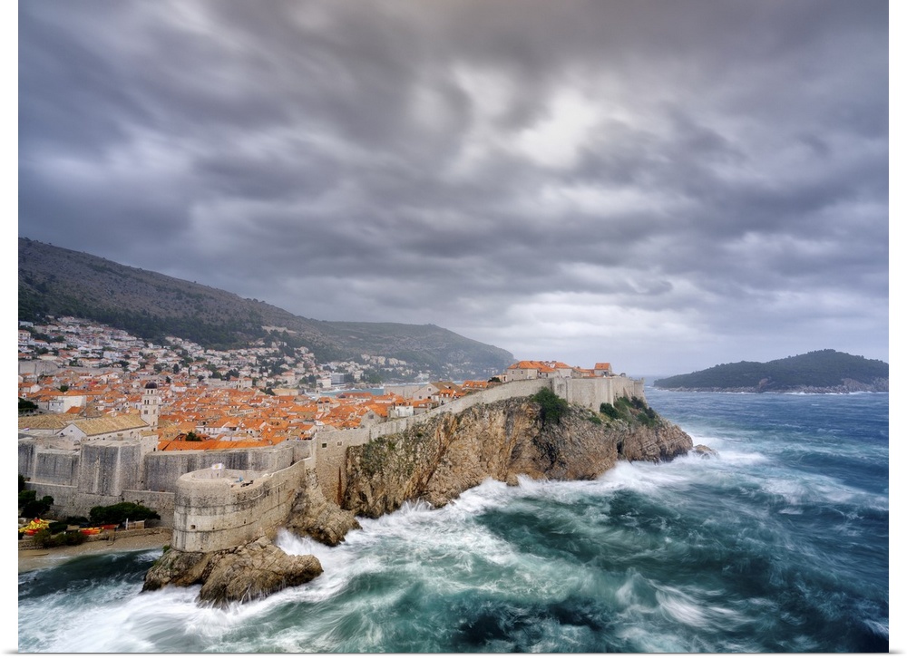 A view towards Dubrovnik Old Town with stormy seas below the city walls.