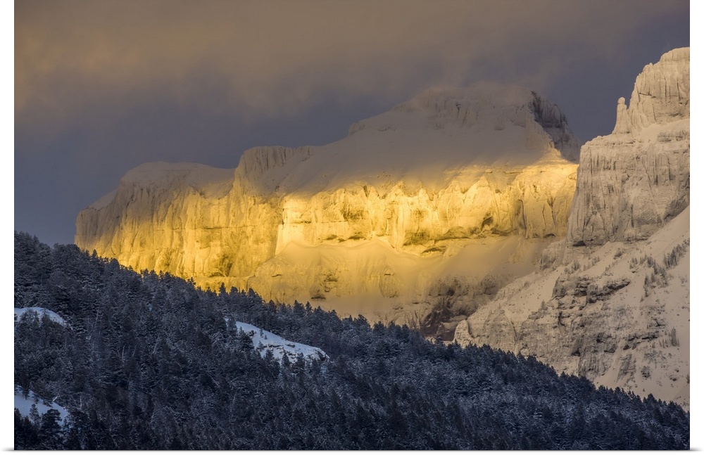 Coated with snow and illuminated with the warm light of sunset, Amphitheater Mountain glows with a wonderful golden color ...
