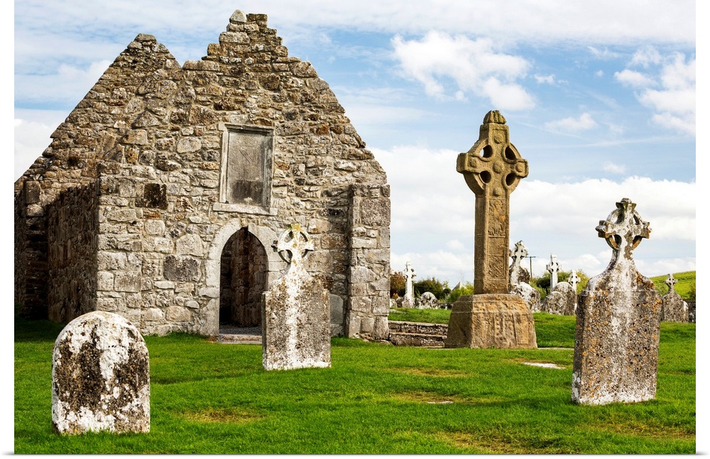 Ancient stone roofless church with celtic crosses in a grassy field, County Offaly, Ireland.