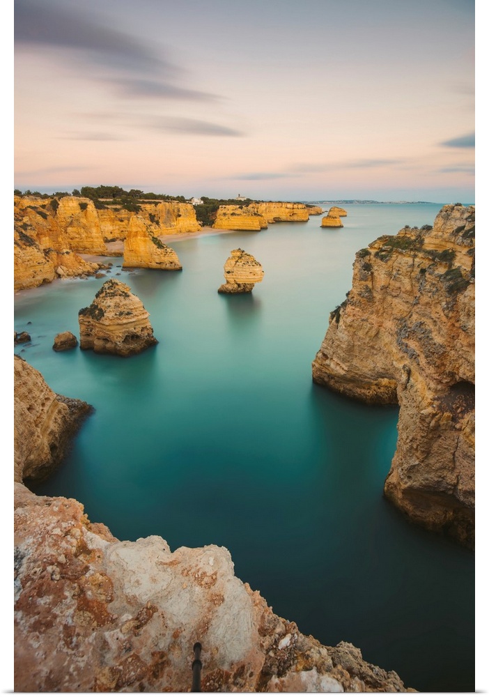 Iconic rock formations and turquoise water of the Atlantic Ocean at Praia da Marinha along the Atlantic coast in Caramujei...