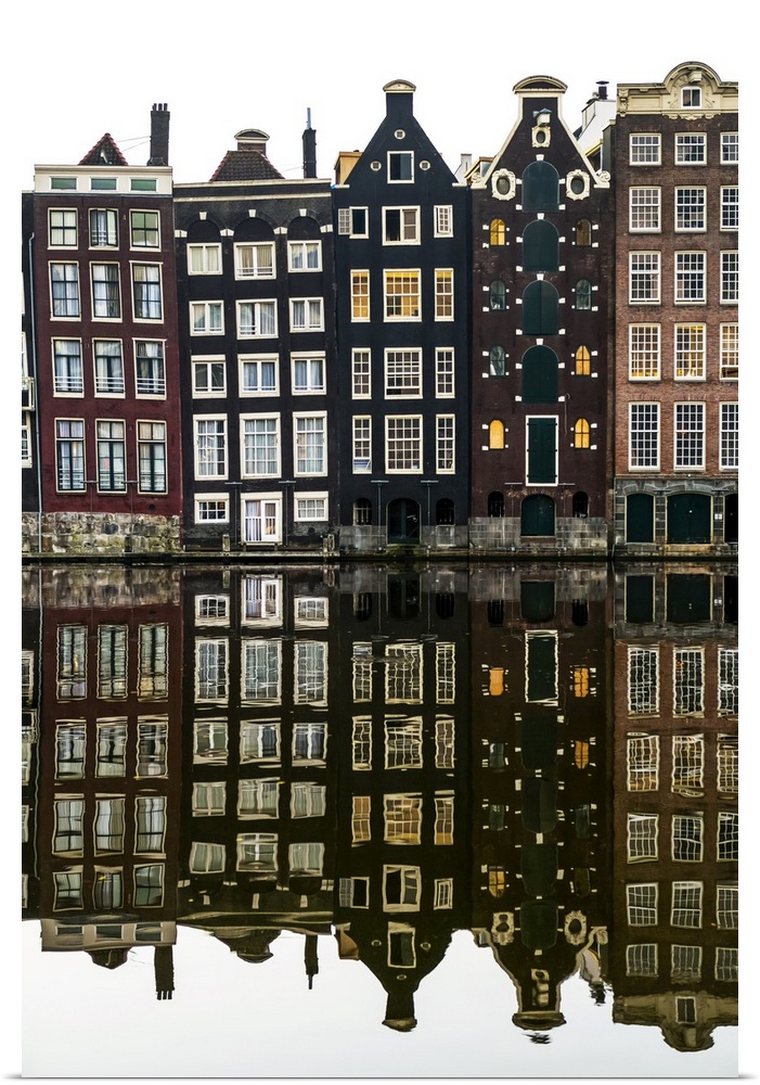 Building facades with a mirror image reflecting in a canal; Amsterdam, Netherlands