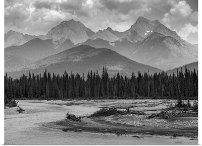 Canadian rocky mountains with a forest and a flowing river in the foreground