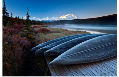 Canoes lined up on a dock at Wonder Lake in front of Mt. McKinley.
