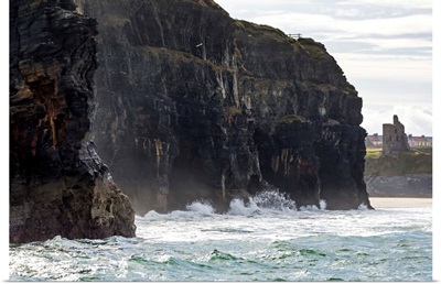 Cliffs with waves crashing into the rock with ruined castle turret, Ballybunion, Ireland