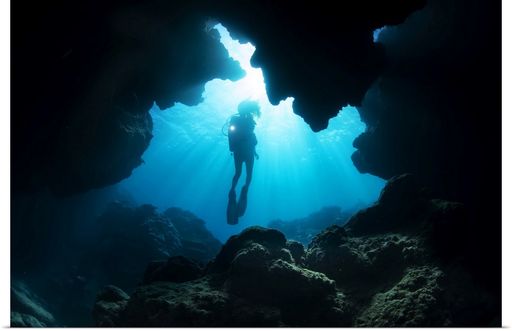 Diver entering a crevice at Yap Cavern's off the very south end of the island of Yap; Yap, Micronesia