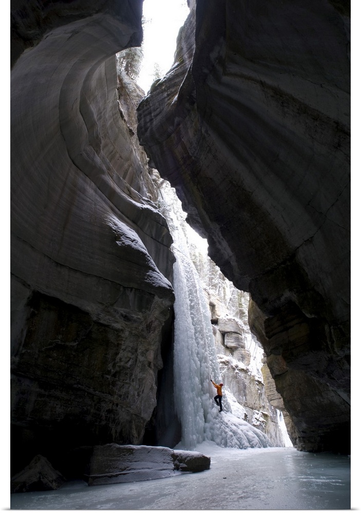 Female Climber Explores Ice Climbing In The Narrows Of Maligne Canyon In Jasper National Park, Alberta, Canada
