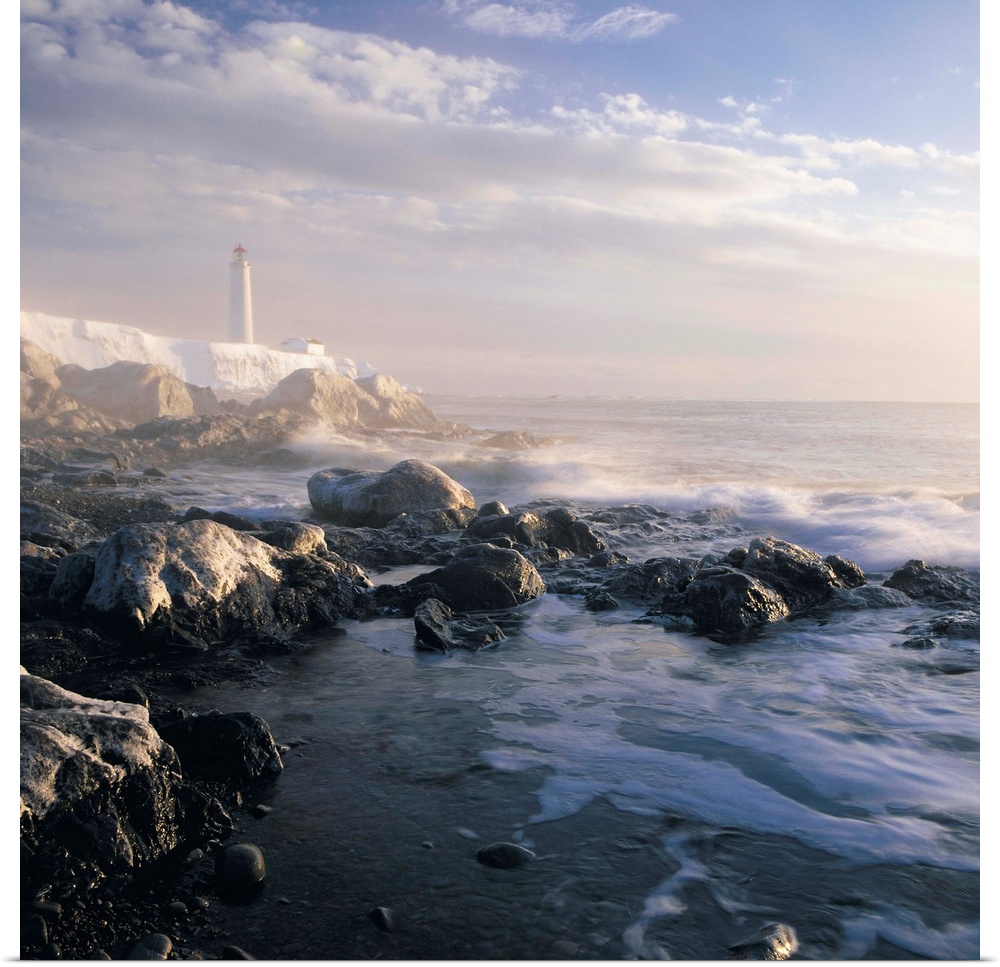 Fog And Rocky Shoreline In Winter With Cap Des Rosiers Lighthouse, Quebec, Canada