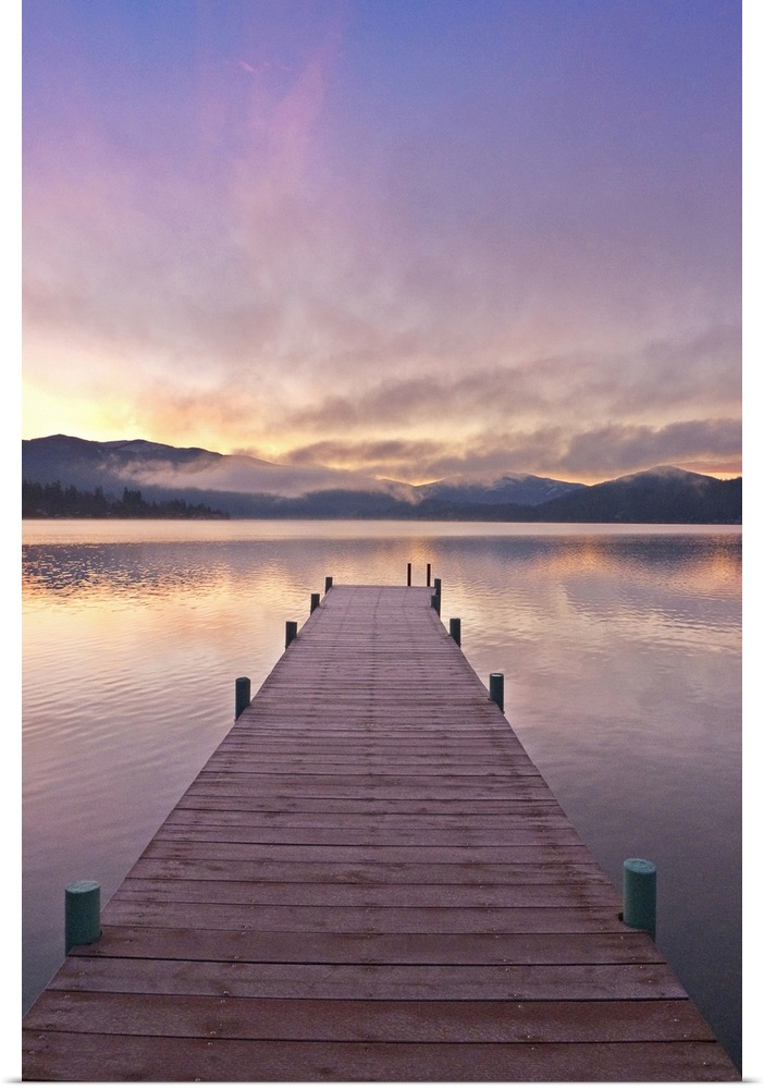 Footprints leading down a frost covered dock at sunrise on Lake Whatcom during Winter, Bellingham Washington, USA.