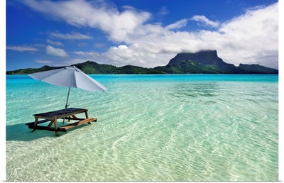 French Polynesia, Tahiti, Bora Bora, Picnic Table And Umbrella In Clear Lagoon Water