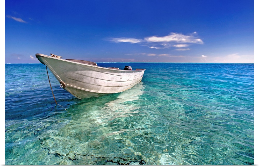 An image print of a wooden boat floating in a crystal clear ocean.