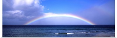 Full Rainbow Over Ocean, Large Clouds Against Blue Sky