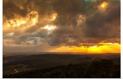 Golden sunset with glowing clouds and silhouetted landscape, Israel