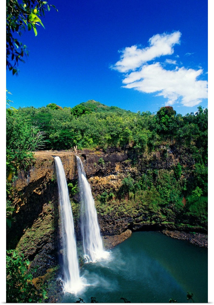 Tall canvas of two waterfalls right next to each other sending water down to the lake below in Hawaii.