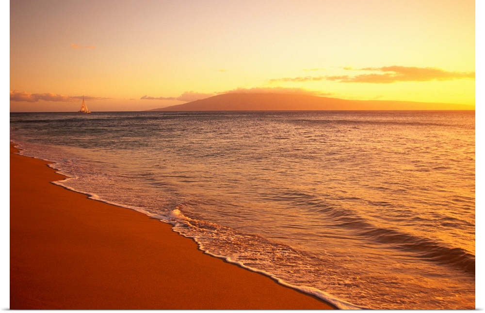 The sun sets out of view over a Hawaiian coast as the ocean water rushes up on the sand and there is a view of a single sa...
