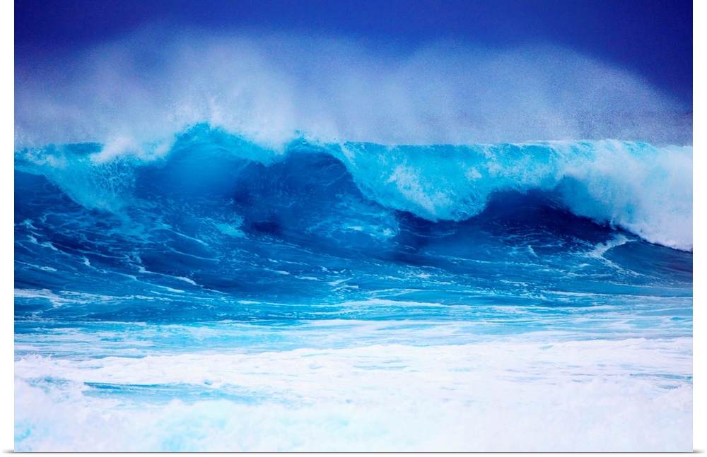 Giant horizontal photograph of a vibrant blue wave spraying upward as it begins to crash onto itself, against a deep blue ...