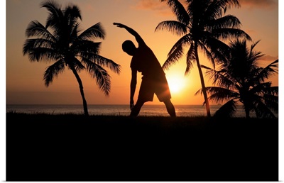 Hawaii, Oahu, Silhouette Of Man Stretching Near The Beach As The Golden Sunsets