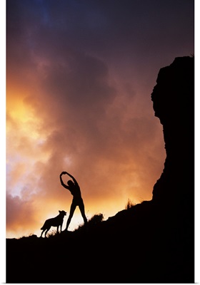 Hawaii, Silhouette Of A Woman Stretching On A Mountain Top At Sunset