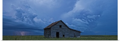 Lightning strikes over the prairies and abandoned farm house, Val Marie, Saskatchewan