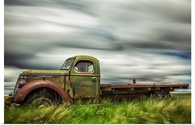 Long exposure of clouds drifting by over an abandoned truck, Saskatchewan, Canada