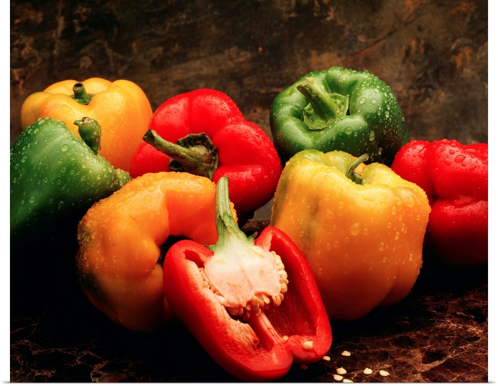 Mixture of green, red and yellow bell peppers, with one red bell pepper cut open