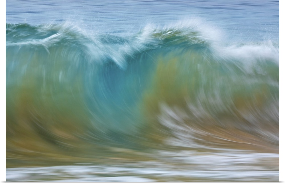 Motion blur of blue rolling waves carrying golden sand at the shore; Kihei, Maui, Hawaii, United States of America.