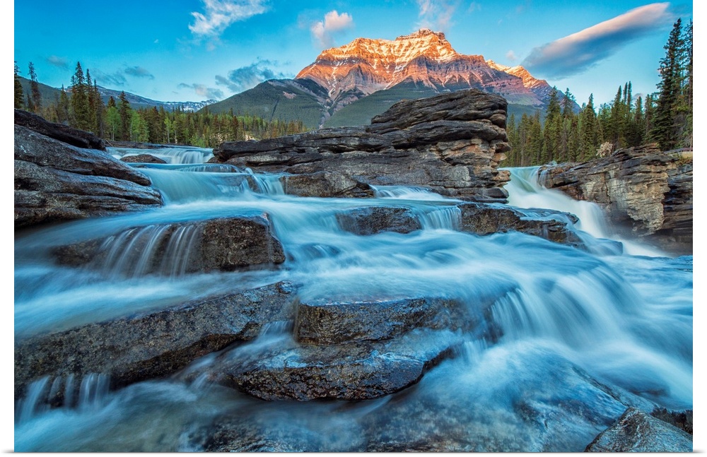 Sunset lights up Mount Fryatt as the Athabasca River flows over Athabasca Falls in Jasper National Park, Alberta, Canada.