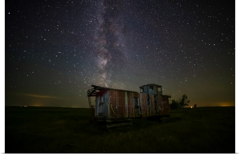 Old caboose at nighttime under a bright, starry sky; Coderre, Saskatchewan, Canada