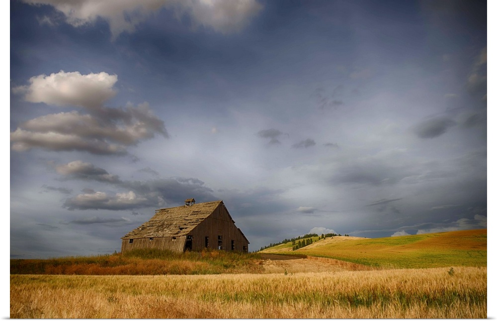 Old wooden barn in a wheat field under a cloudy sky, Palouse, Washington, United States of America.