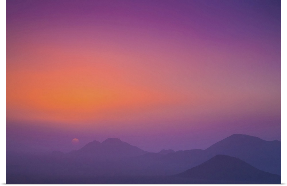 A pink and purple sky with silhouetted mountains; Namibia