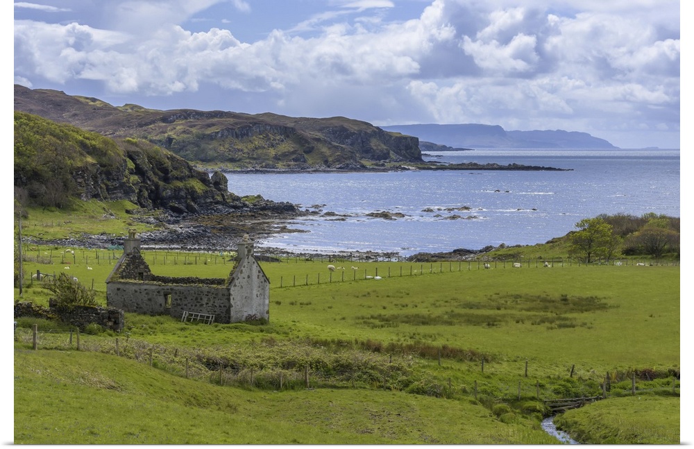 Remains of a stone house in grassy field along the coast on the Isle of Skye in Scotland, United Kingdom