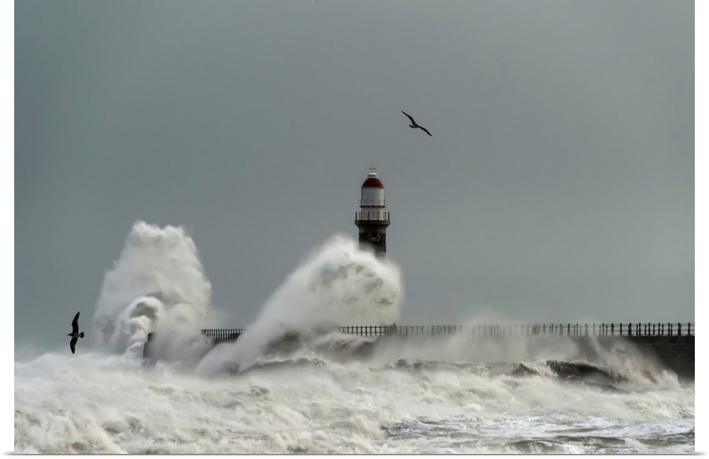 Roker lighthouse and waves from the river ware crashing onto the pier. Sunderland, Tyne and Wear, England.